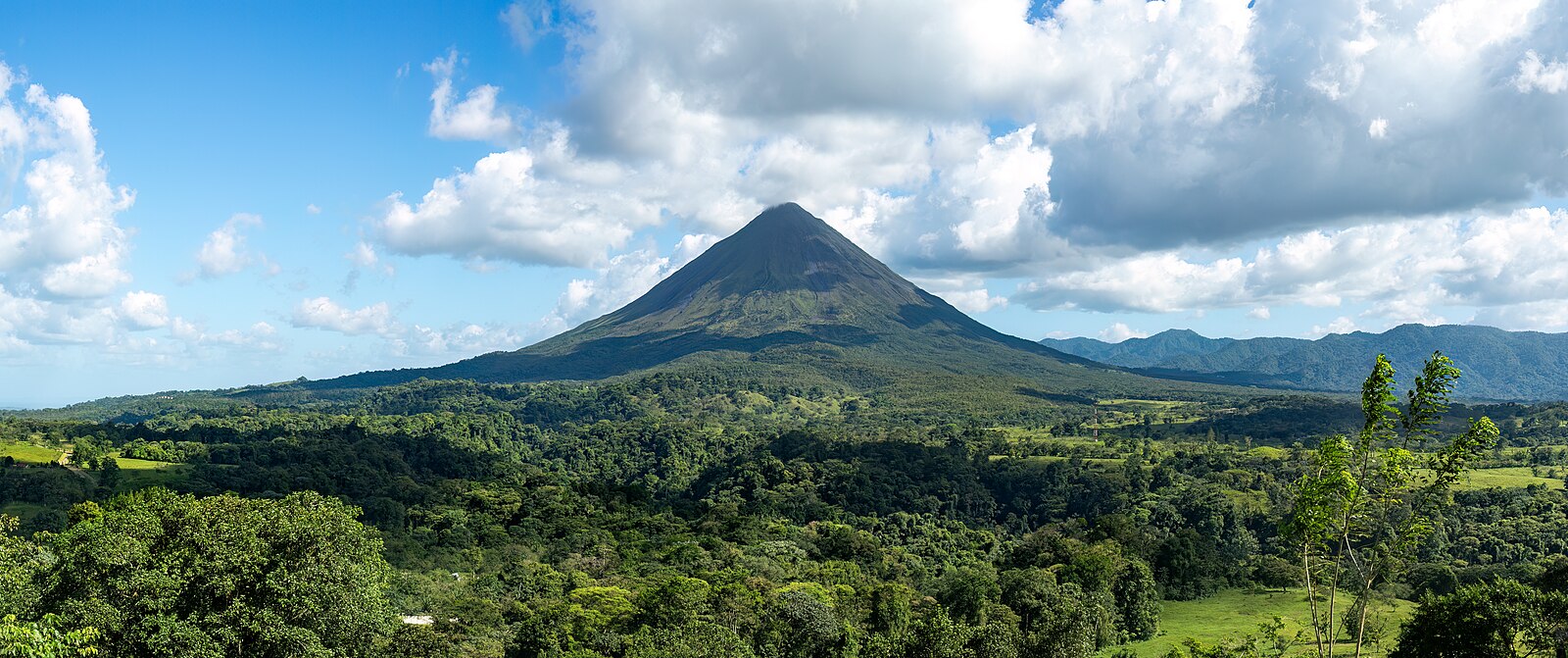 Arenal Volcano panoramic landscape in Costa Rica with lush rainforest foreground